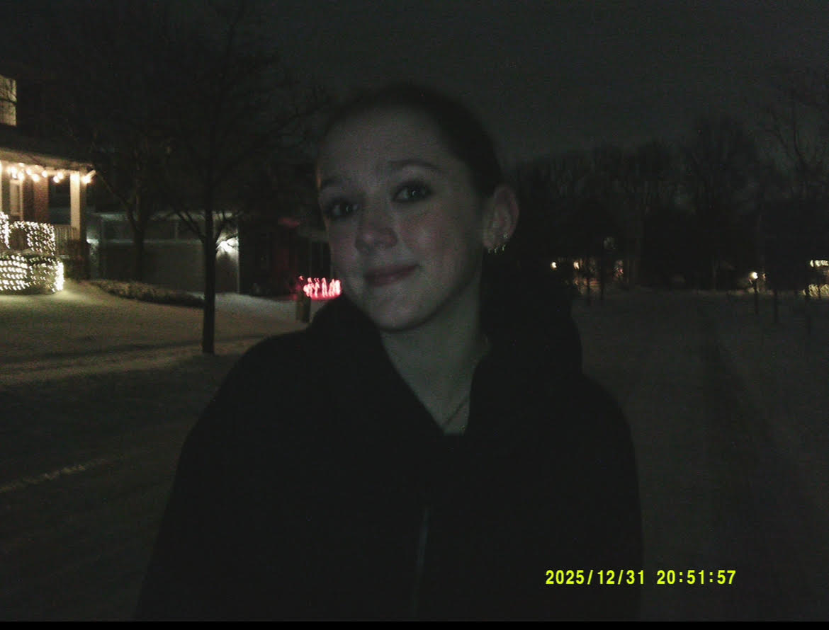 Ava Poff standing  on a sidewalk late at night in winter.