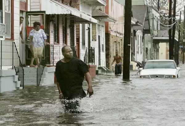 People walking out of their homes into flooded streets after Hurricane Katrina.