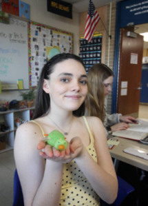 Sophie Weber holding a squishy duck in her hands during class. 